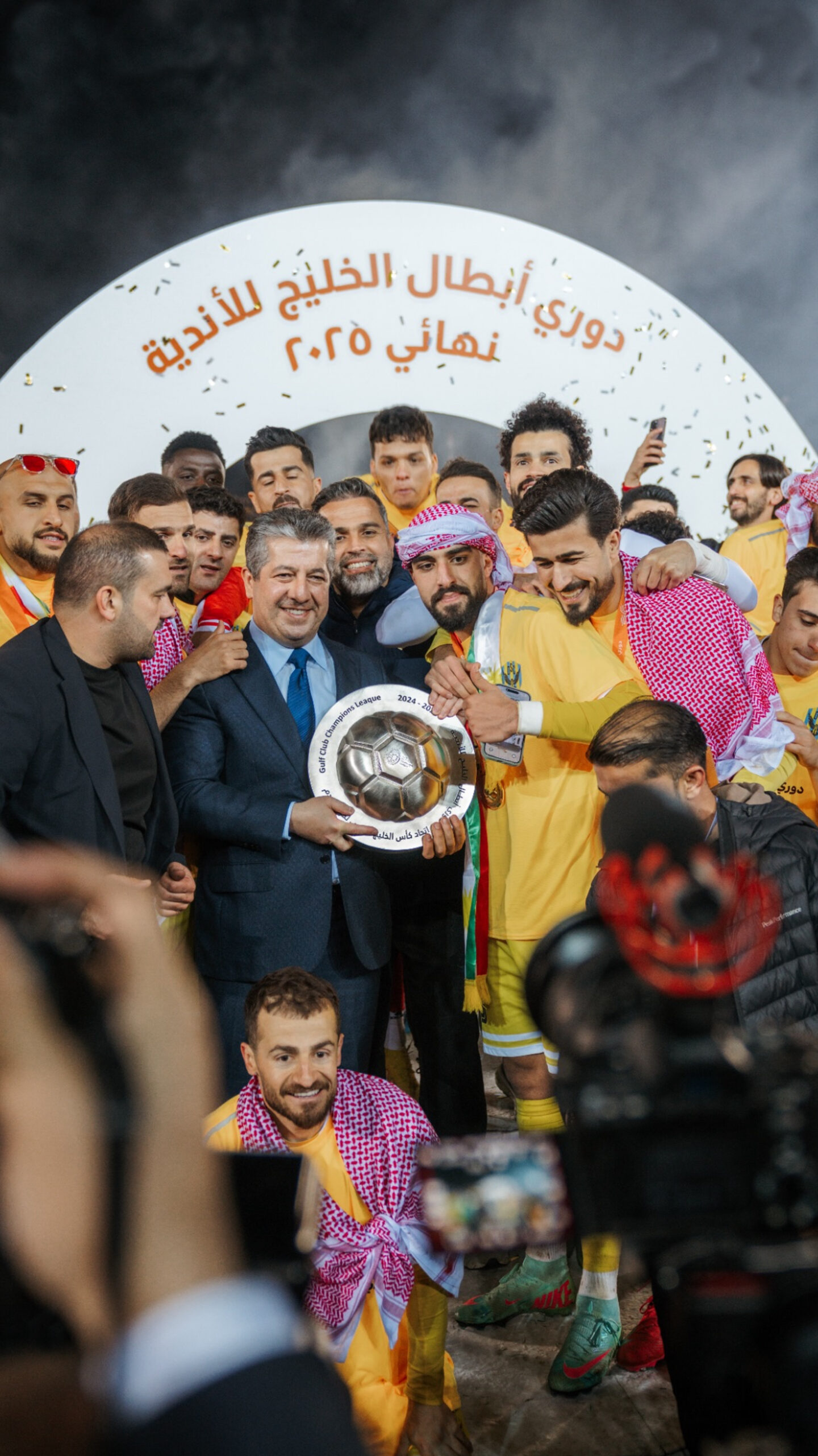 Time de futebol comemorando conquista de titulo com trofeu